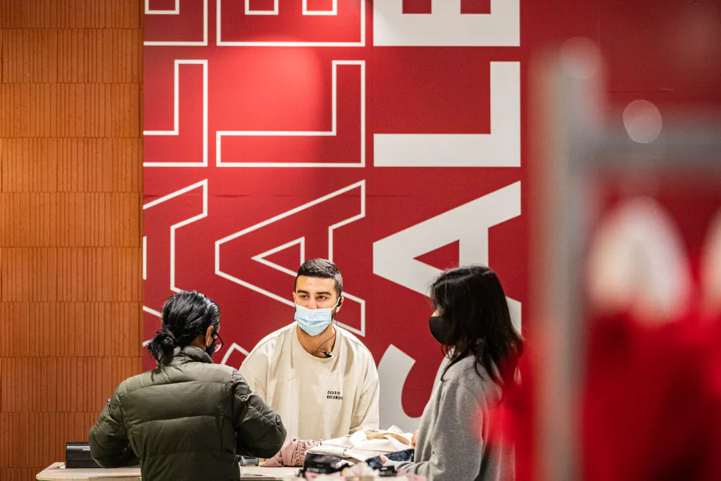 A customer representative serves customers at Glue store during the Boxing Day sales in Melbourne, Australia, on Dec. 26, 2021. (Diego Fedele/Getty Images)