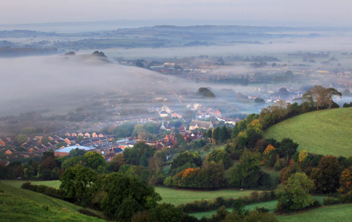 The sun begins to rise over the morning mist above the town of Glastonbury on Oct. 13, 2009. (Matt Cardy/Getty Images)