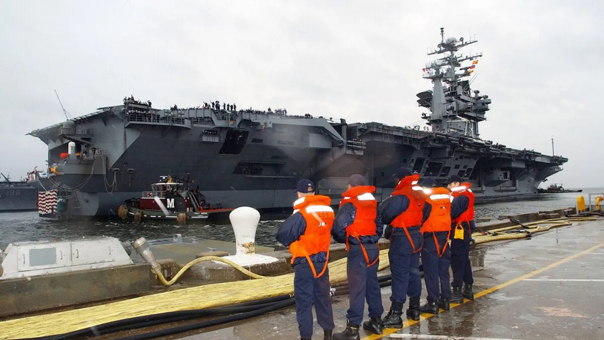 Line handlers wait to help dock the aircraft carrier USS George Washington as tug boats work to move the behemoth at its home port in Norfolk, Virginia, on Dec. 20, 2002. (Michael Sandberg/U.S. Navy/Getty Images)