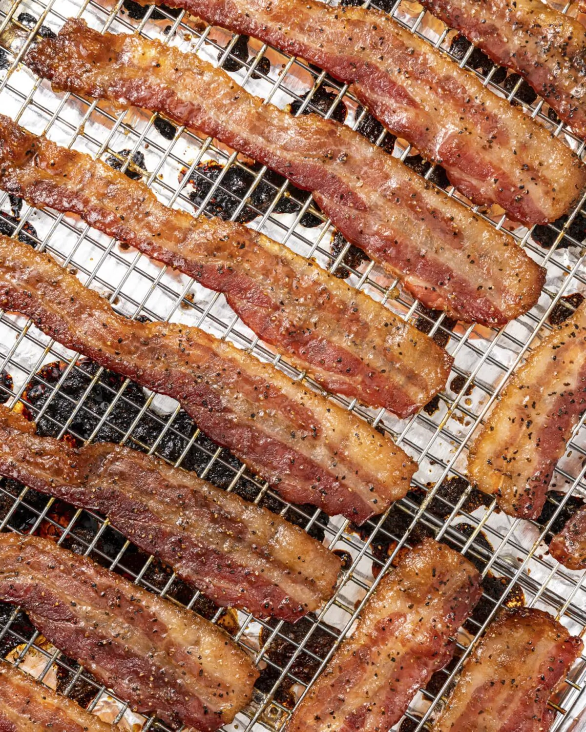 Bake brown sugar-crusted bacon slices until the strips sizzle and the edges curl from the molten sugar. (Photo courtesy of Eric Kleinberg/TNS)