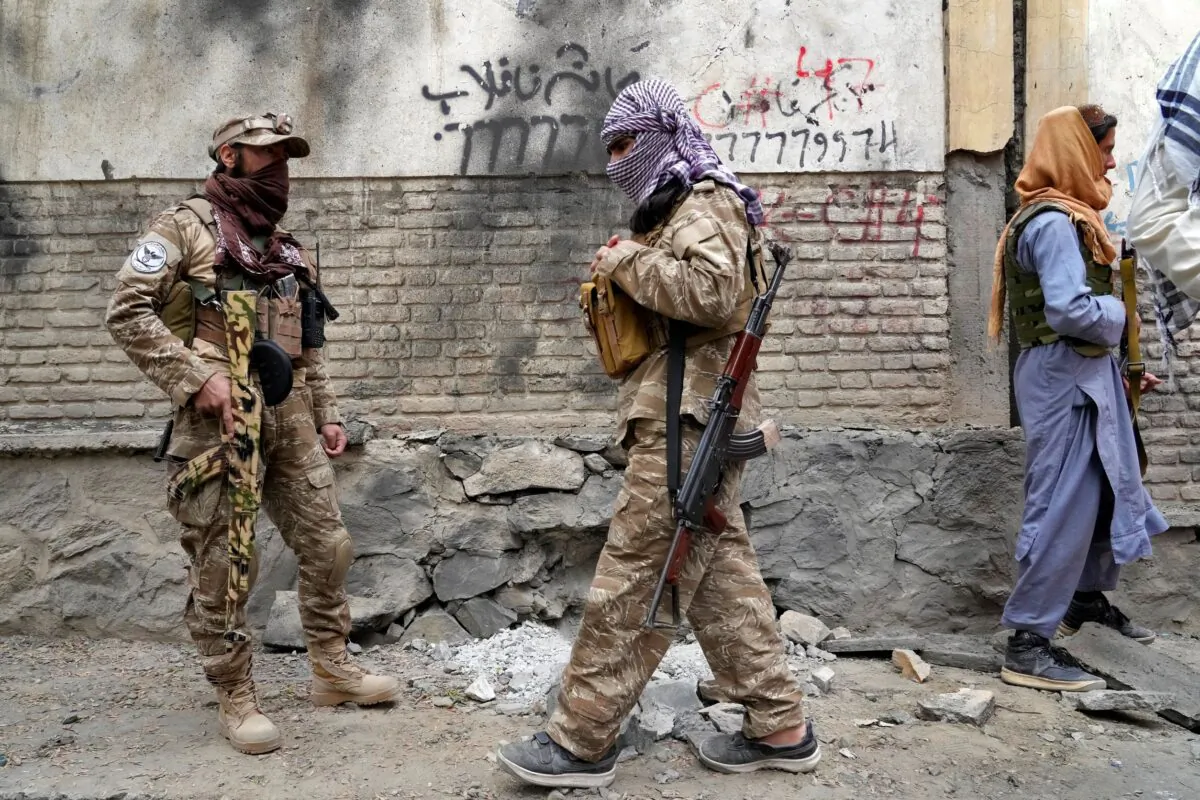 Taliban fighters stand guard at the site of an explosion in front of a school, in Kabul, Afghanistan, on April 19, 2022. (Ebrahim Noroozi/AP Photo)