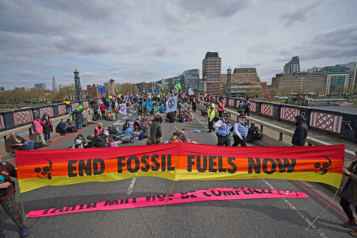 In an undated file photo activists unfurl a giant banner on Lambeth Bridge as they block it in protest over fossil fuel use, in London. (Yui Mok/PA)