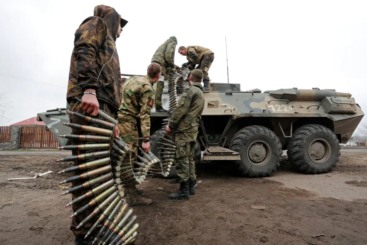 Service members of pro-Russian troops load ammunition into an armored personnel carrier during fighting in Ukraine-Russia conflict in the southern port city of Mariupol, Ukraine, on April 12, 2022. (Alexander Ermochenko/Reuters)