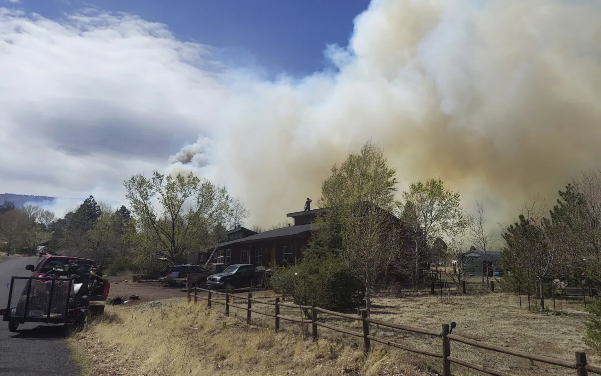Smoke from a wind-whipped wildfire rises above neighborhoods on the outskirts of Flagstaff, Arizona, on April 19, 2022. (Sean Golightly/Arizona Daily Sun via AP)