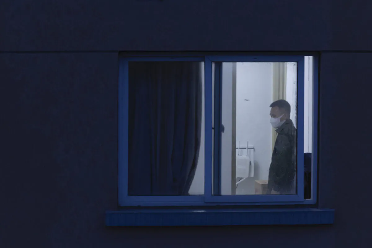 A man wearing a protective face mask is seen through a window at his home in a residential area in Shanghai, China, on April 13, 2022. (Getty Images/Getty Images)
