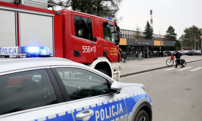 A police car and a firefighters' truck before the Pniowek coal mine in Pawlowice, southern Poland, on April 20, 2022, where two underground methane explosions killed five people and injured more than 20 early Wednesday. (AP Photo)