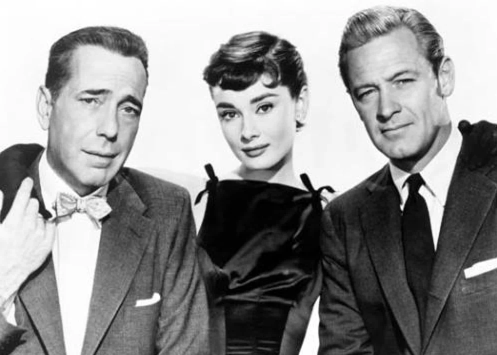 Publicity photo of Humphrey Bogart (L), Audrey Hepburn & William Holden (R) taken for the film Sabrina (1954). (Public Domain)