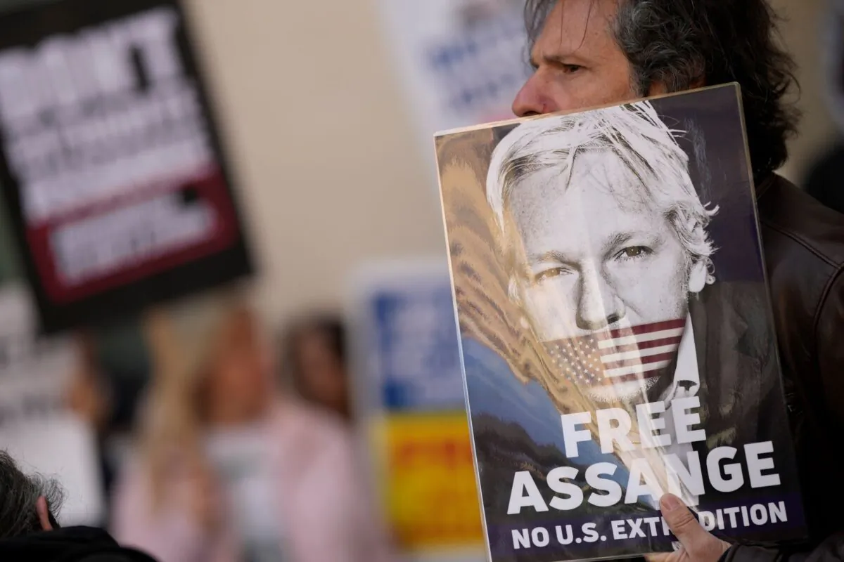 Wikileaks founder Julian Assange supporters hold placards as they gather outside Westminster Magistrates court In London, on April 20, 2022. (Alastair Grant/AP Photo)