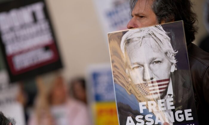 Wikileaks founder Julian Assange supporters hold placards as they gather outside Westminster Magistrates court In London, on April 20, 2022. (Alastair Grant/AP Photo)