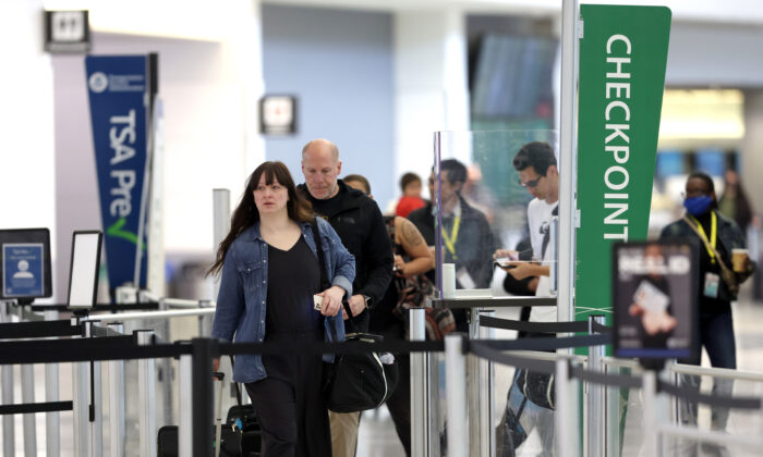Airline passengers without masks prepare to enter a security checkpoint at San Francisco International Airport on April 19, 2022. (Justin Sullivan/Getty Images)