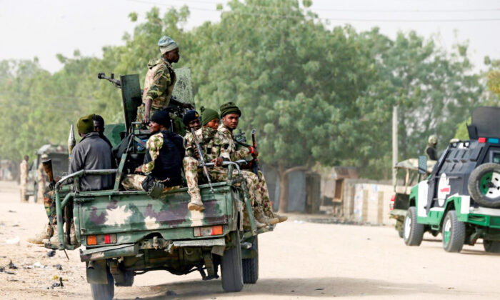 Nigerian military ride on their truck as they secure the area where a man was killed by suspected militants during an attack around Polo area of Maiduguri, Nigeria, on Feb. 16, 2019. (Afolabi Sotunde/Reuters)