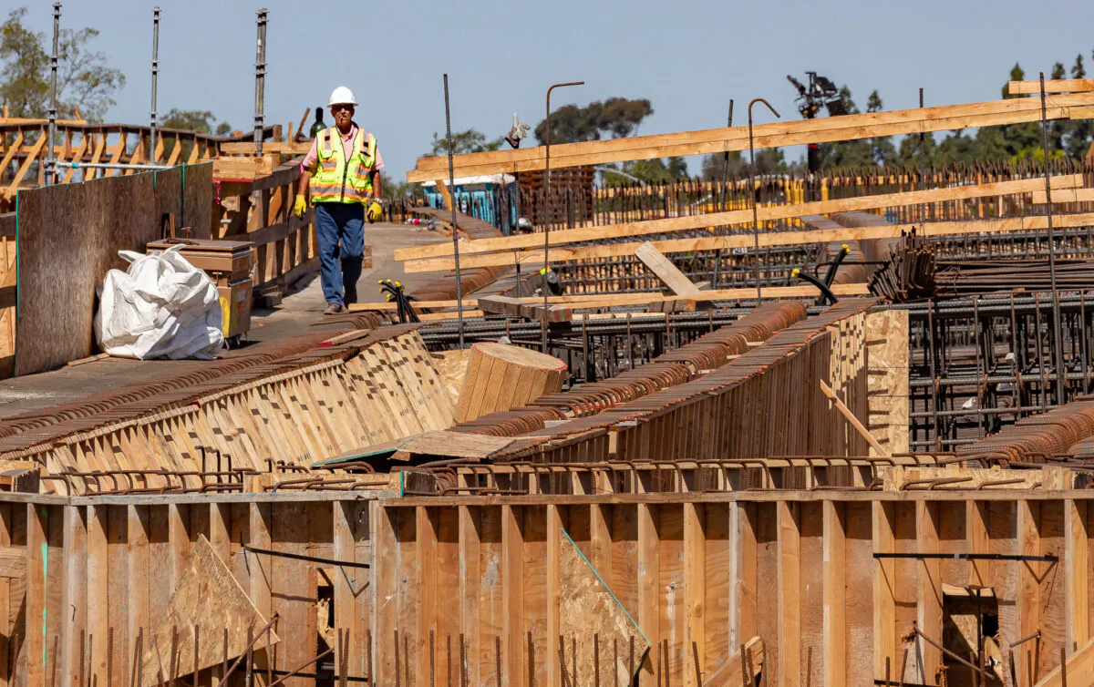 A worker heads down a walkway as freeway construction continues on the State Route 73 southern interchange from the Interstate 405 in Costa Mesa, Calif., on April 21, 2022. (John Fredricks/The Epoch Times)