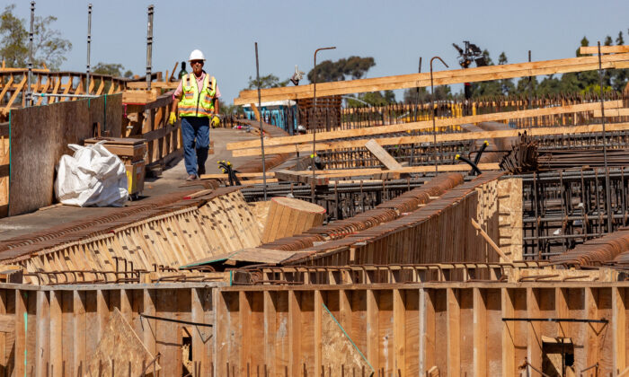 A worker heads down a walkway as freeway construction continues on the State Route 73 southern interchange from the Interstate 405 in Costa Mesa, Calif., on April 21, 2022. (John Fredricks/The Epoch Times)