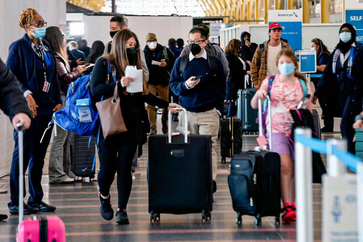 Travelers walk through Ronald Reagan Washington National Airport in Arlington, Va., on April 19, 2022. (Stefani Reynolds/AFP via Getty Images)
