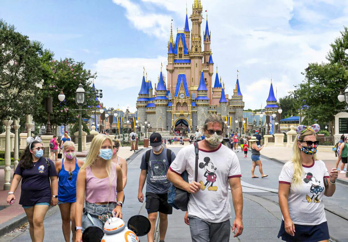 Guests wear masks as required to attend the official reopening day of the Magic Kingdom at Walt Disney World in Lake Buena Vista, Fla, on, July 11, 2020. (Joe Burbank/Orlando Sentinel via AP)