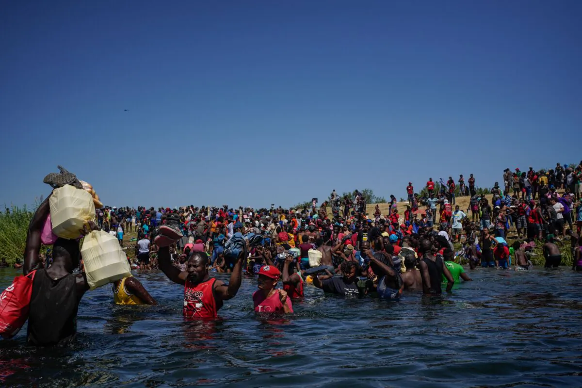 Haitian migrants, part of a group of over 10,000 people staying in an encampment on the U.S. side of the border, cross the Rio Grande river to get food and water in Mexico, after another crossing point was closed near the Acuna Del Rio International Bridge in Del Rio, Texas, on Sept. 19, 2021. (Paul Ratje/AFP via Getty Images)