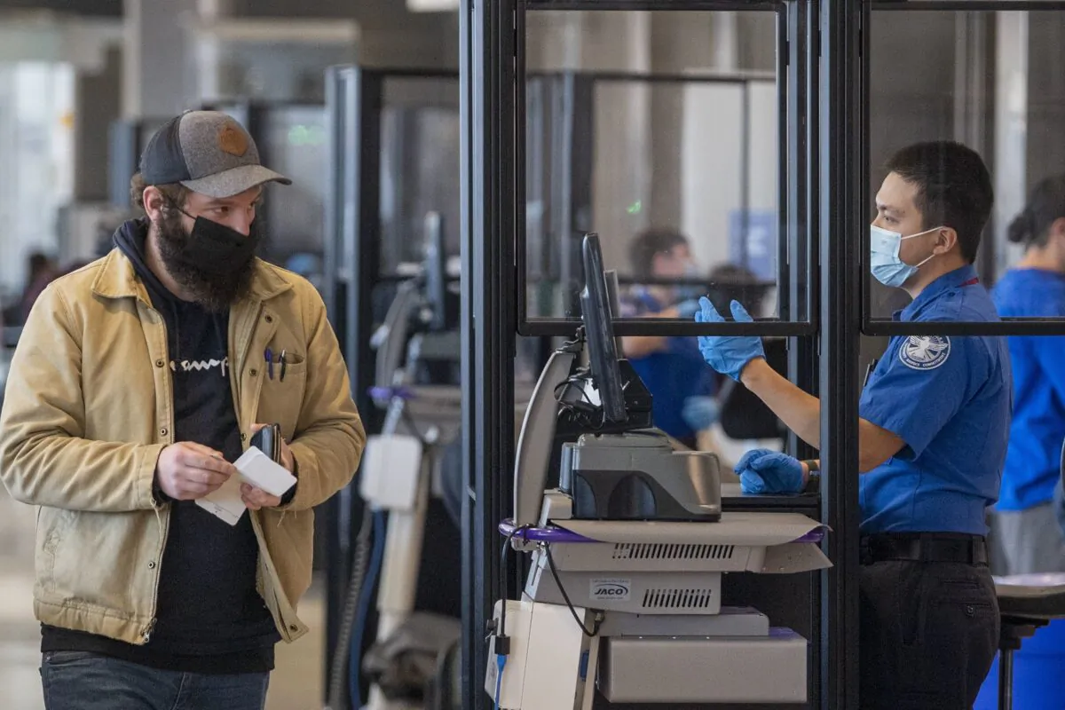 Travelers go through TSA security checkpoints at Philadelphia International Airport. Despite a federal judge’s ruling, masks are still required inside the airport. (TNS)