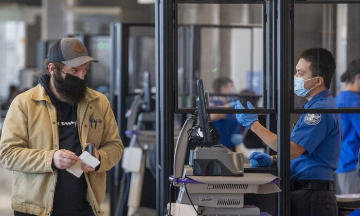 Travelers go through TSA security checkpoints at Philadelphia International Airport. Despite a federal judge’s ruling, masks are still required inside the airport. (TNS)