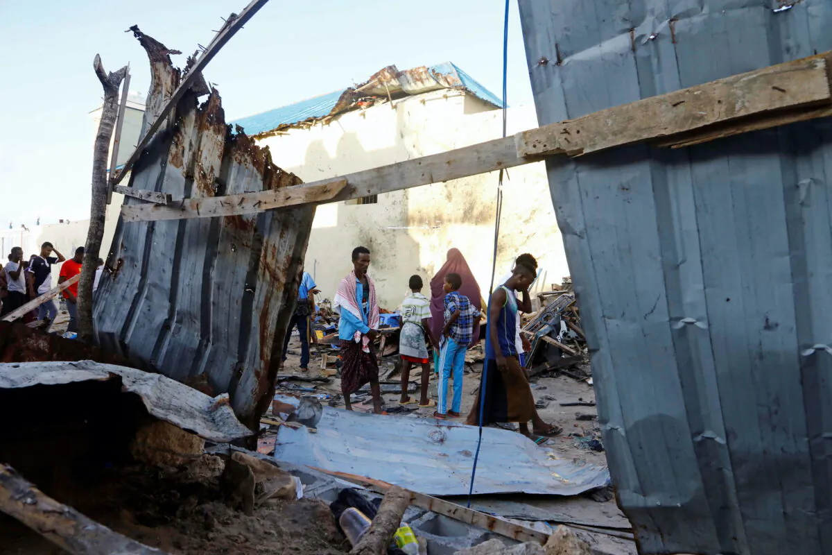 Bystanders walk through the scene of bombing at a seaside restaurant at Lido beach in Mogadishu, Somalia, on April 23, 2022. (Feisal Omar/Reuters)