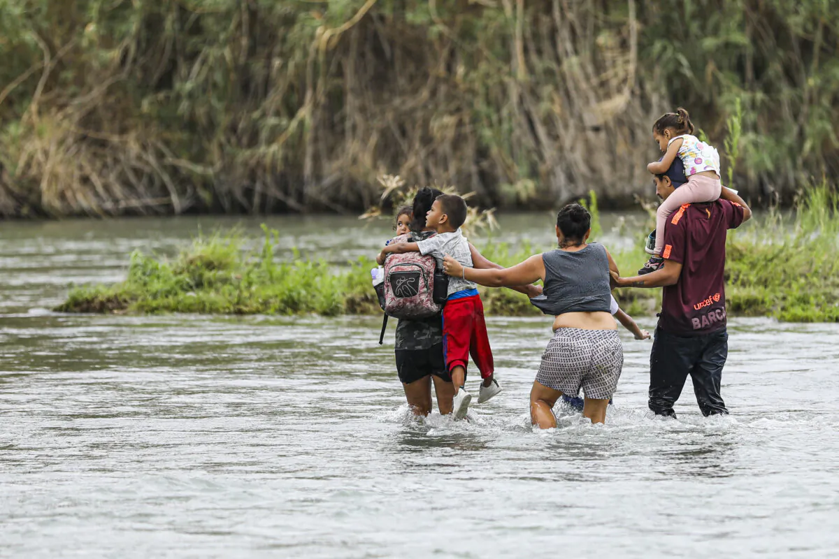 A group of Hondurans cross the Rio Grande toward Eagle Pass, Texas, from Piedras Negras, Mexico, on April 21, 2022. (Charlotte Cuthbertson/The Epoch Times)