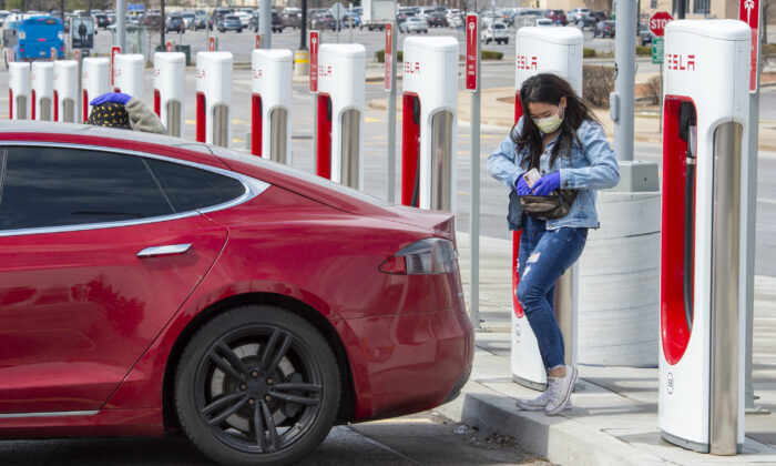 A woman prepares to plug in her electric vehicle in Markham, Ont., in a file photo. (The Canadian Press/Frank Gunn)