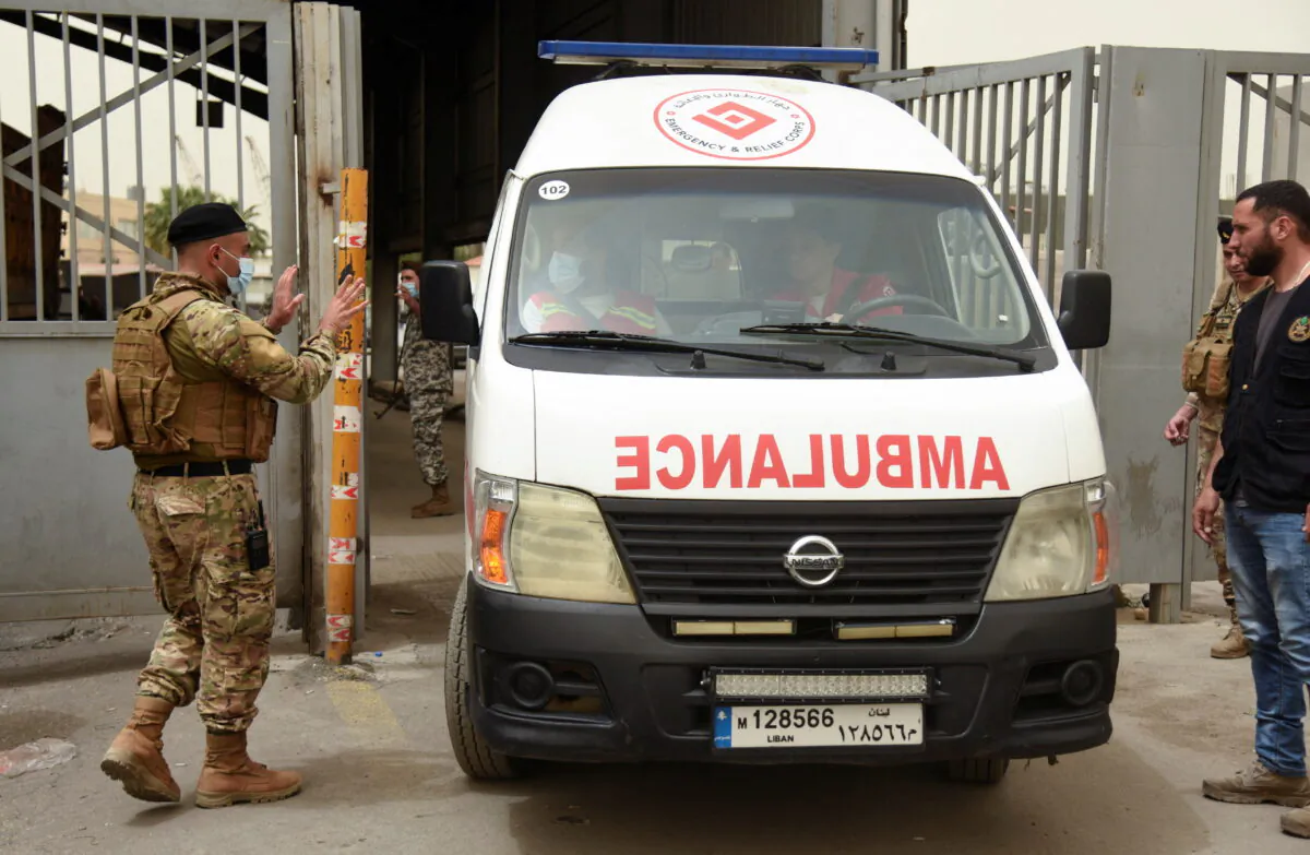 A Lebanese army soldier gestures to health workers inside an ambulance after a boat capsized off the Lebanese coast of Tripoli overnight, at the entrance of port of Tripoli, northern Lebanon, on April 24, 2022. (Omar Ibrahim//Reuters)