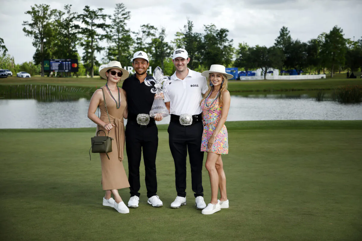 Patrick Cantlay pose with his partner Nikki Guidish and Xander Schauffele and his wife Maya after their team putted in to win on the 18th green during the final round of the Zurich Classic of New Orleans at TPC Louisiana in Avondale, Louisiana, on April 24, 2022. (Chris Graythen/Getty Images)