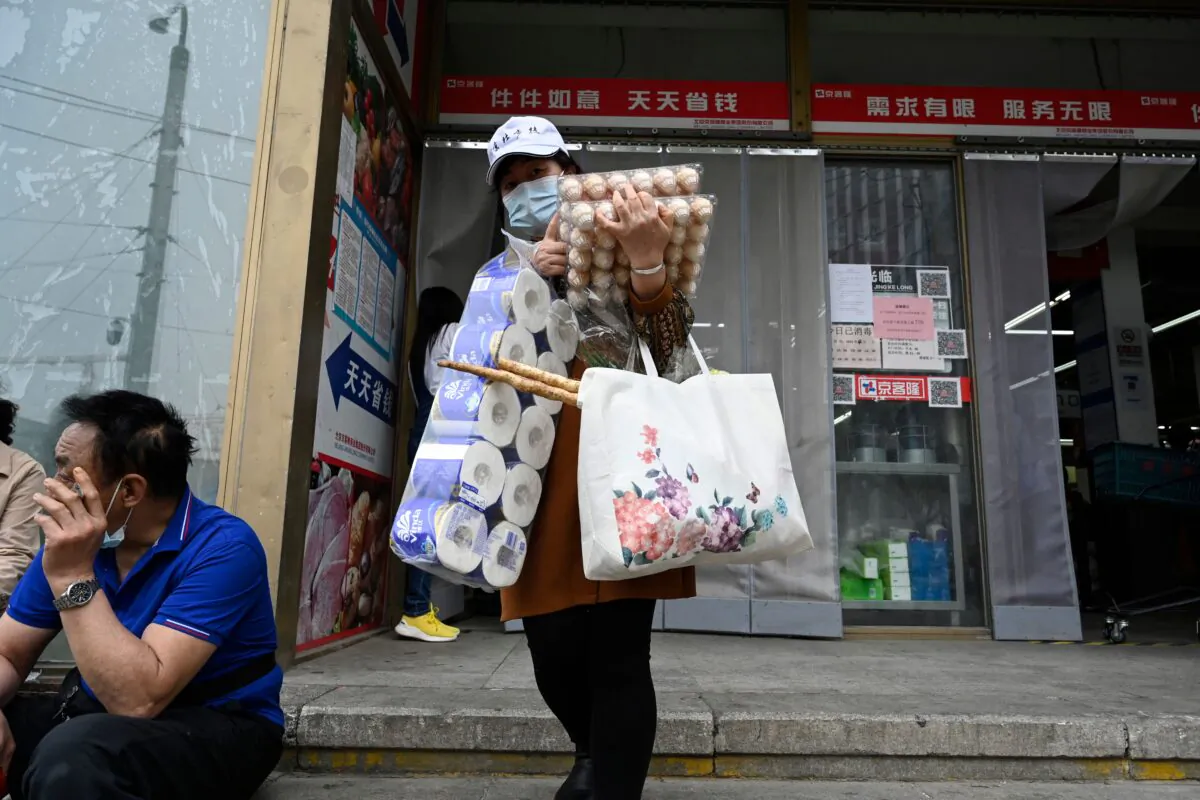 A woman leaves a supermarket after buying food and household provisions in Beijing on April 25, 2022. (JADE GAO/AFP via Getty Images)