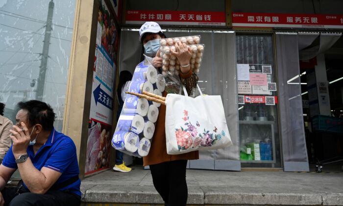 A woman leaves a supermarket after buying food and household provisions in Beijing on April 25, 2022. (JADE GAO/AFP via Getty Images)