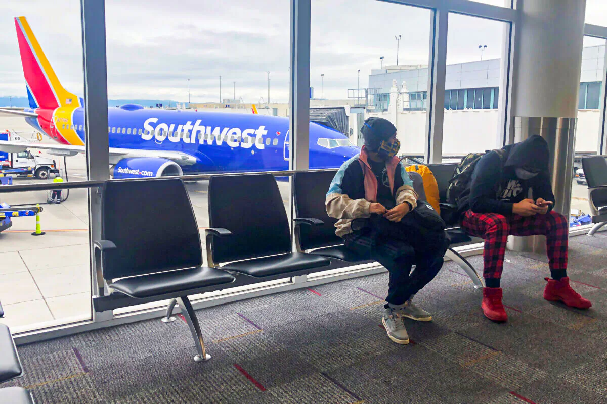 Air travelers wear face masks waiting to board a Southwest Airlines flight at Oakland International airport in Oakland, Calif., on April 9, 2020. (Shannon Stapleton/Reuters)