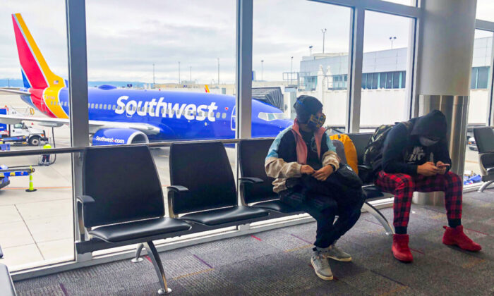 Air travelers wear face masks waiting to board a Southwest Airlines flight at Oakland International airport in Oakland, Calif., on April 9, 2020.  (Shannon Stapleton/Reuters)