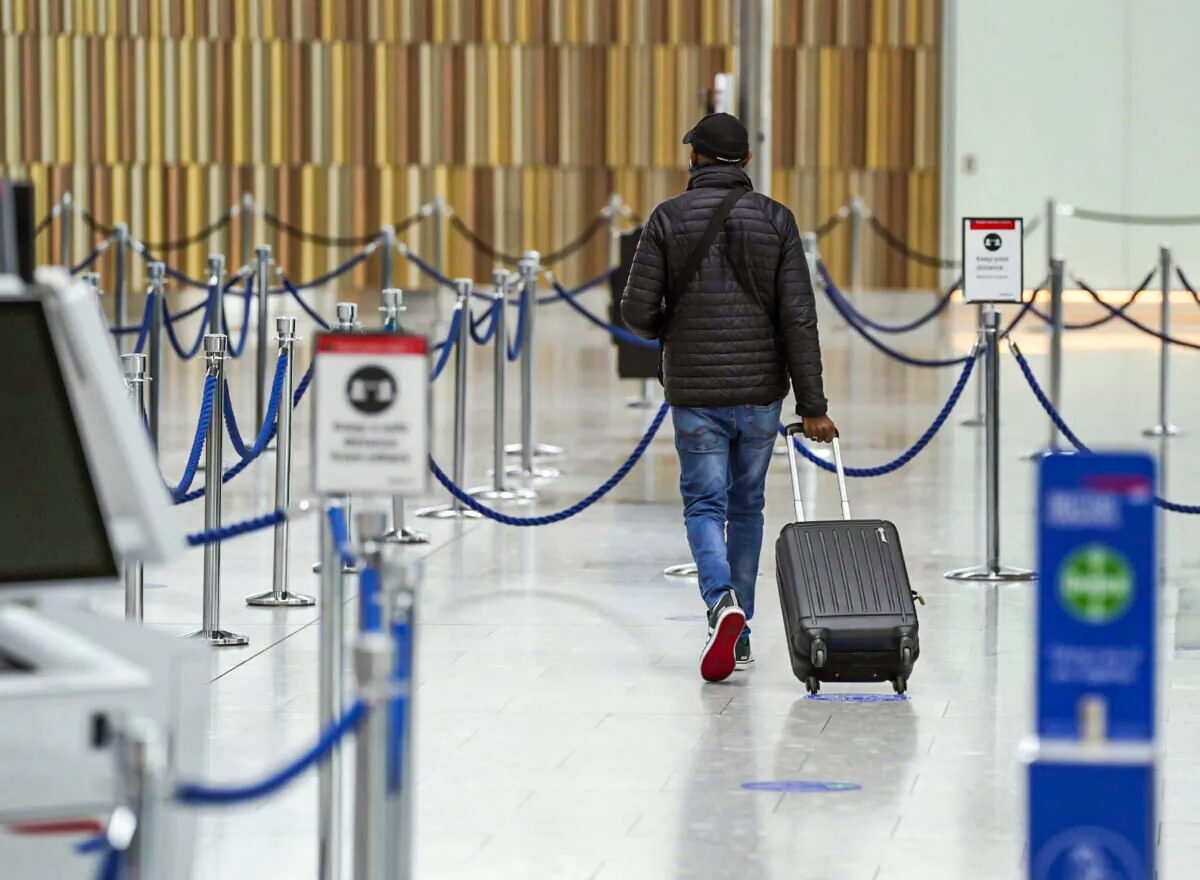 A passenger checks into their flight in the departures area in Terminal 5 at Heathrow Airport in west London on May 13, 2021. (Steve Parsons/PA)