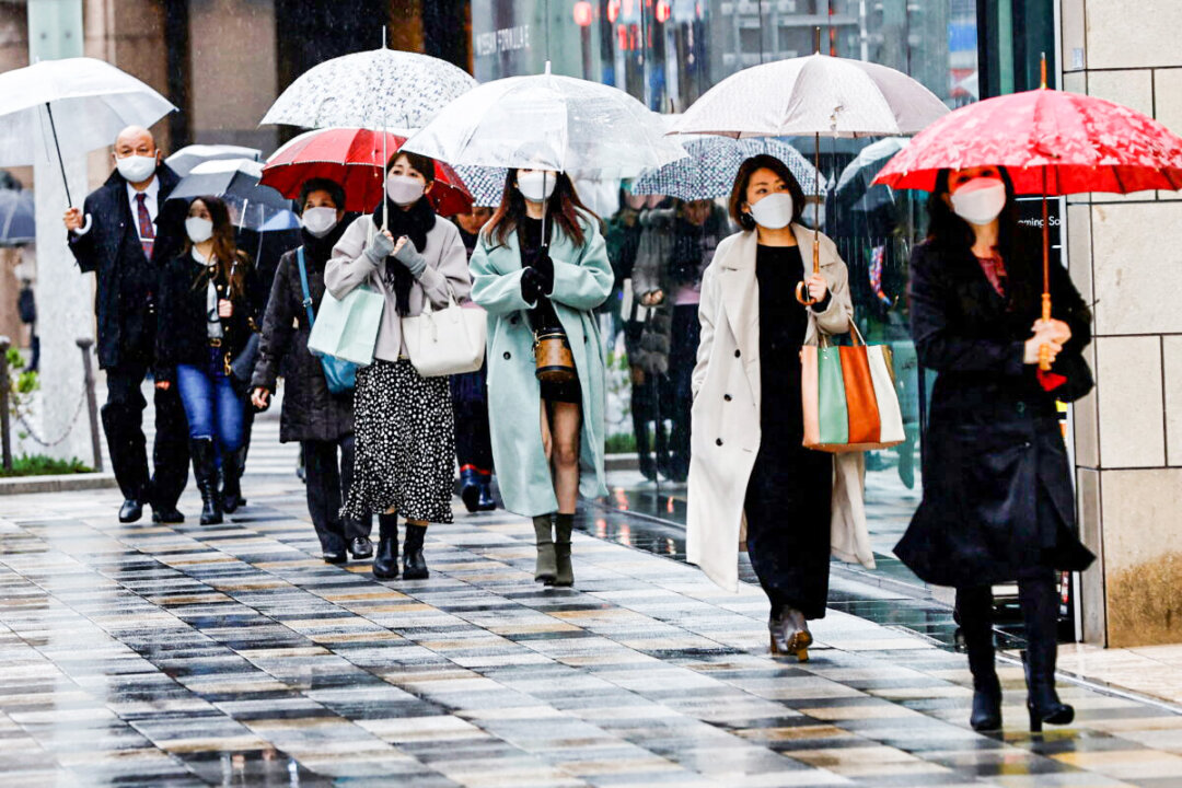Pedestrians wearing protective face masks amid COVID-19 walk at a shopping district in Tokyo, on March 22, 2022. (Kim Kyung-Hoon/Reuters)