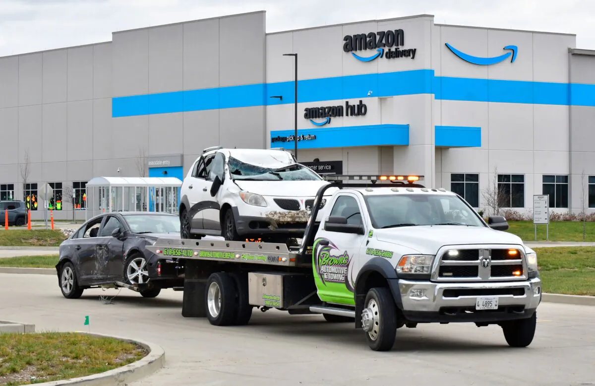 A tow truck removes destroyed cars from an Amazon Fulfillment Center in Edwardsville, IL on Dec. 11, 2021, after it was hit by a tornado. (Tim Vizer / AFP via Getty Images)