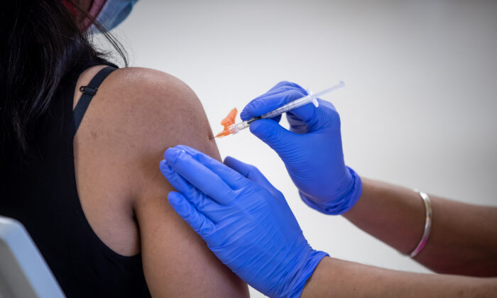 A woman receives a COVID-19 vaccine at a clinic in Surrey, B.C., on May 14, 2021. (The Canadian Press/Darryl Dyck)