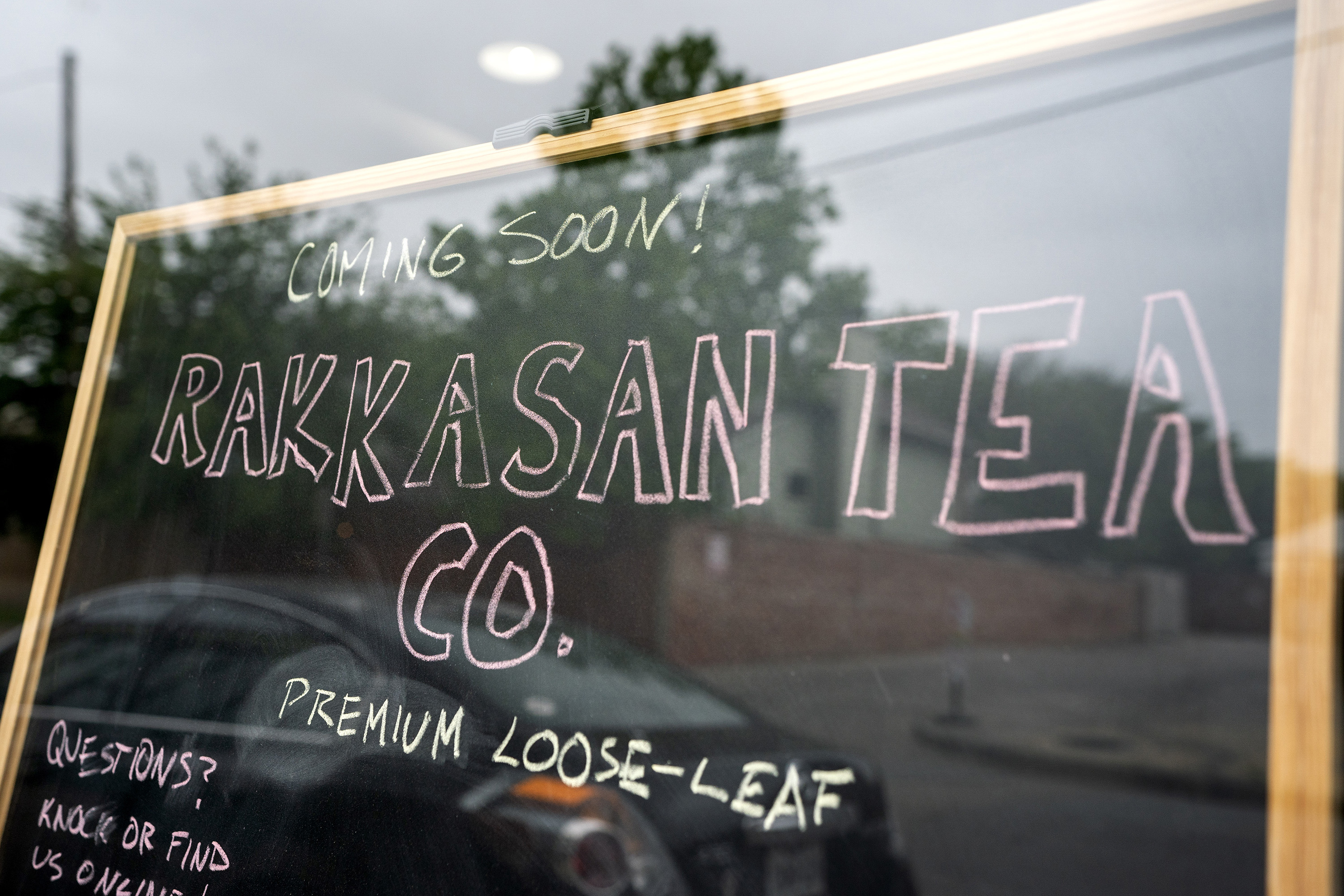 A sign in the front window announces the opening of Rakkasan Tea's new brick-and-mortar storefront .