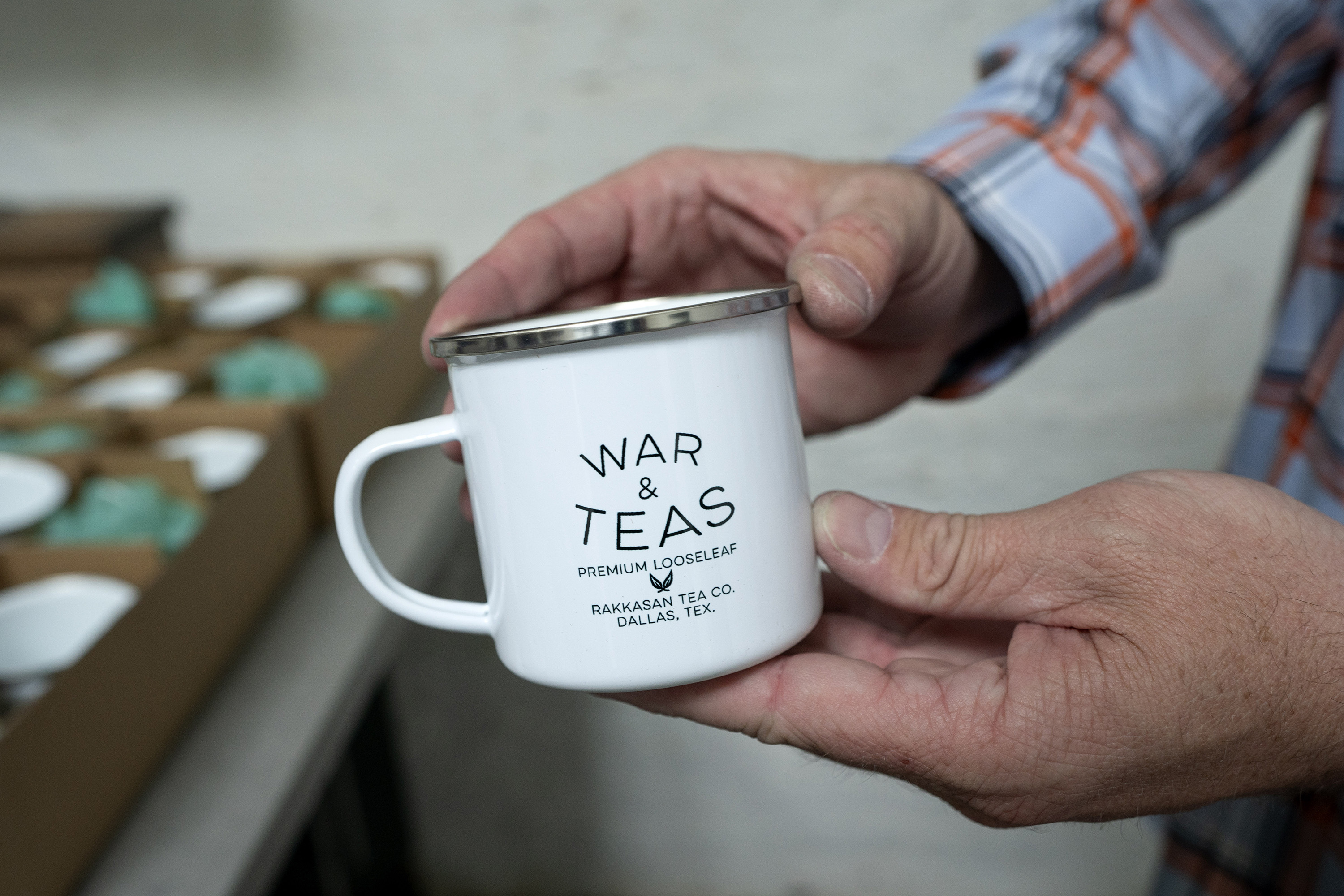 TK Kamauf holds a Rakkasan Tea branded tea cup .