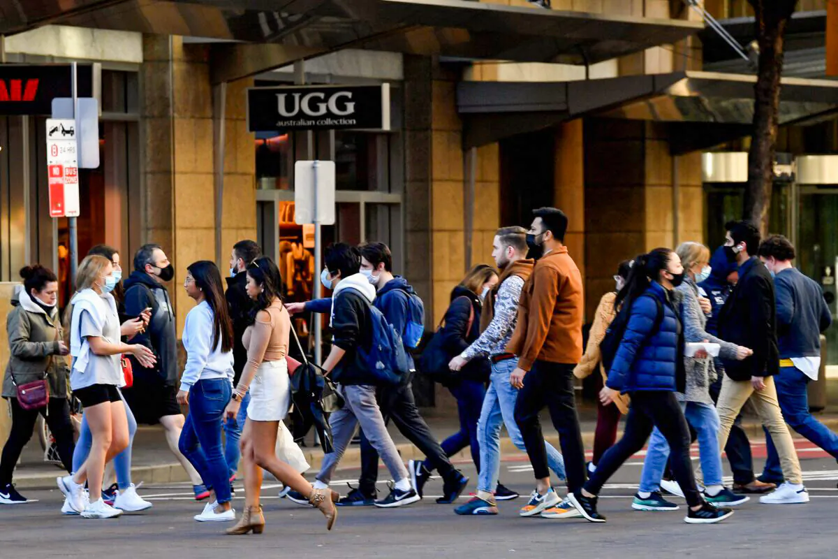 People wearing face masks walk on a street in the central business district of Sydney in Australia, on June 25, 2021. (Saeed Khan/AFP via Getty Images)