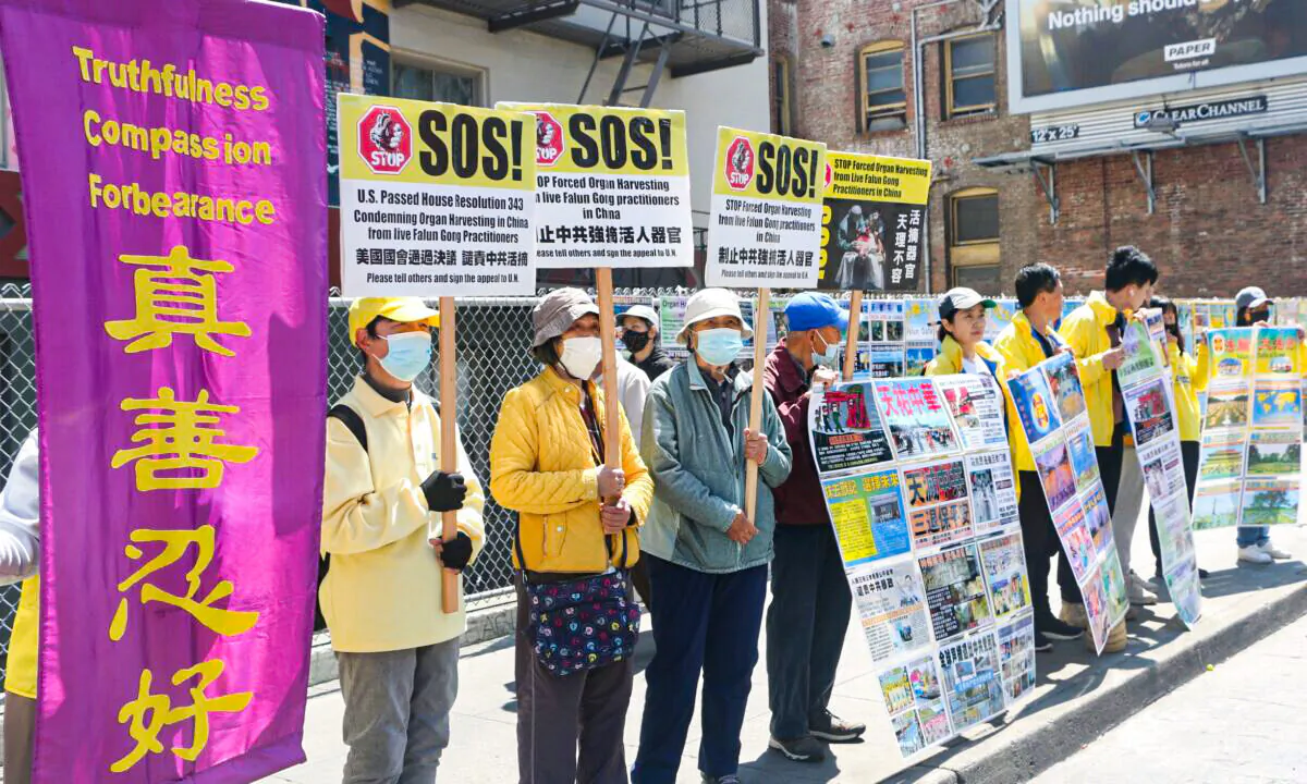 Locals hold signs in San Francisco’s Chinatown on April 23, 2022. (David Lam/The Epoch Times)