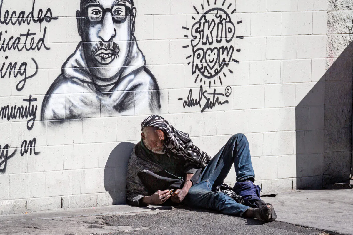 A homeless man uses drugs in Los Angeles on June 9, 2021. (John Fredricks/The Epoch Times)
