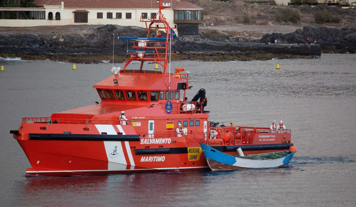 A Spanish maritime rescue vessel arrives with a wooden boat in tow at the port of Los Cristianos on the island of Tenerife after it was found drifting off the coast of the Spanish Canary Islands, on April 28, 2021. (Desiree Martin/AFP via Getty Images)