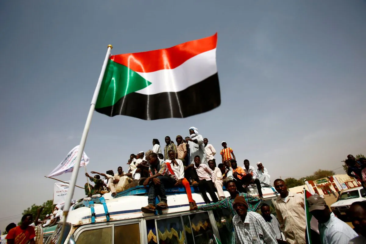Sudanese wave national flags during a rally in the town of Zalingei, capital of Central Darfur state on April 3, 2016. (Ashraf Shazly/AFP via Getty Images)