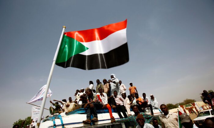 Sudanese wave national flags during a rally in the town of Zalingei, capital of Central Darfur state on April 3, 2016. (Ashraf Shazly/AFP via Getty Images)