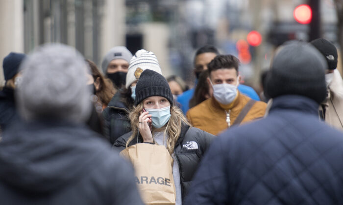 People wear face masks as they walk along a street in Montreal, on Dec. 5, 2020, amid the COVID-19 pandemic. (The Canadian Press/Graham Hughes)
