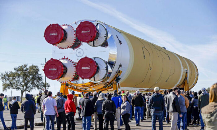 Employees and contractors watch as the core stage of NASA's Space Launch System rocket, that will be used for the Artemis 1 Mission, is moved to the Pegasus barge, at the NASA Michoud Assembly Facility where it was built, in New Orleans, La., on Jan. 8, 2020. (Gerald Herbert/AP Photo)