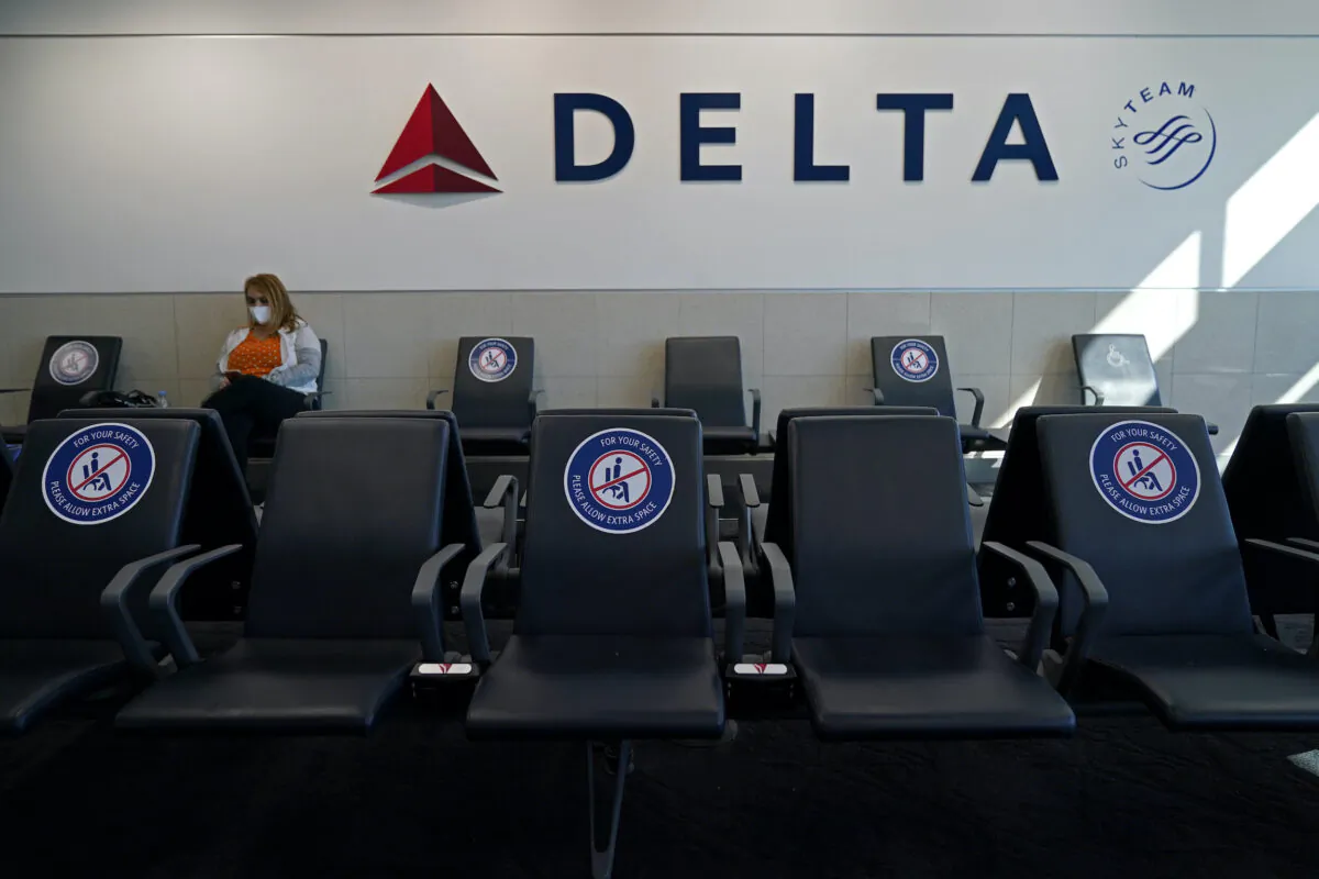 A passenger wears a face mask as she waits in a socially-distanced area for a Delta Airlines flight, at Hartsfield-Jackson International Airport in Atlanta, on Feb. 3, 2021.  (Charlie Riedel/AP Photo)