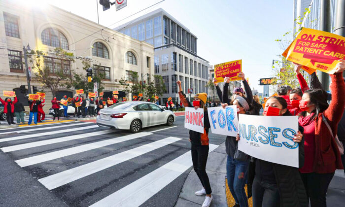 Sutter Health nurses and health care workers hold signs as they participate in a one day strike outside of the California Pacific Medical Center Van Ness Campus in San Francisco, California, on April 18, 2022. (Justin Sullivan/Getty Images)