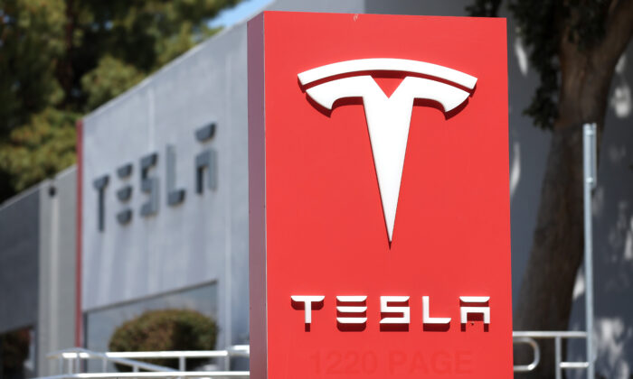 A sign is posted in front of a Tesla service center in Fremont, Calif., on April 20, 2022. (Justin Sullivan/Getty Images)