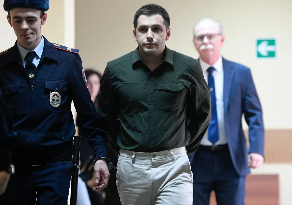 Russian police officers escort U.S. ex-marine Trevor Reed, charged with attacking police, into a courtroom prior to a hearing in Moscow on March 11, 2020. (Alexander Nemenov/AFP via Getty Images)