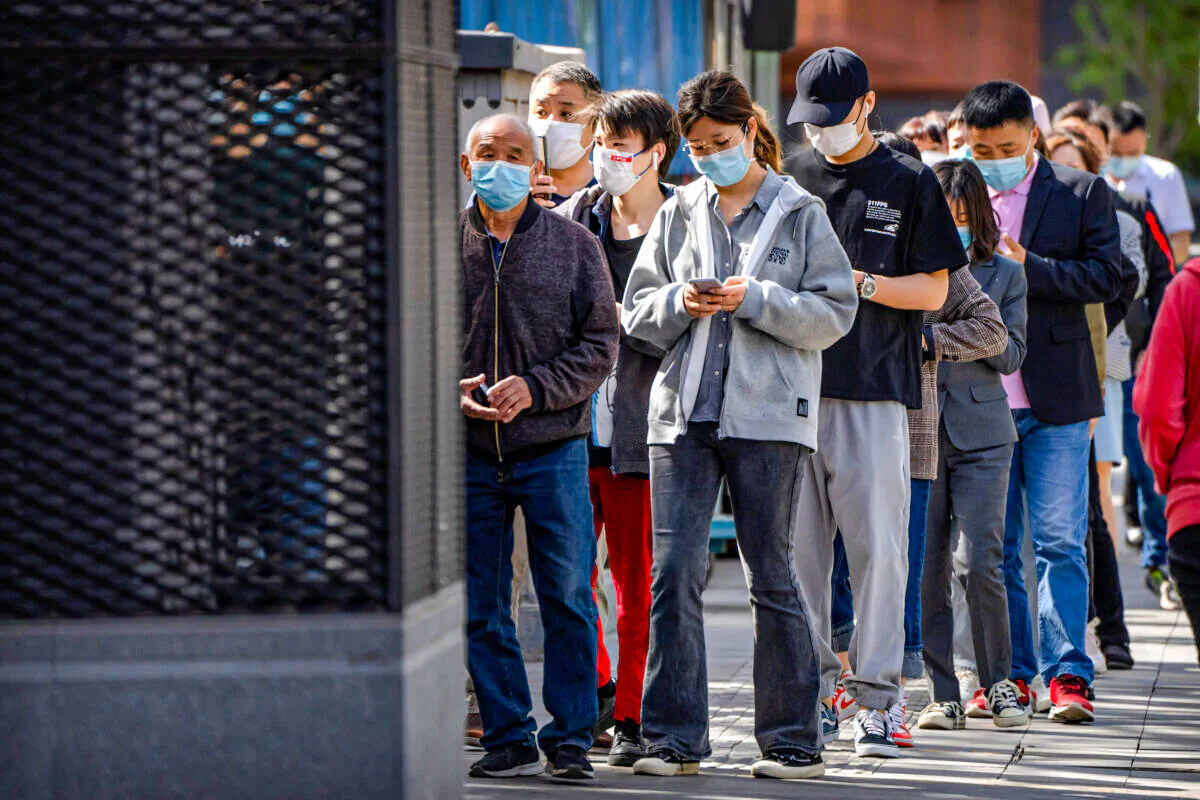 People stand in line for coronavirus tests in a neighborhood in the Dongcheng district of Beijing on April 26, 2022. (Mark Schiefelbein/AP Photo)